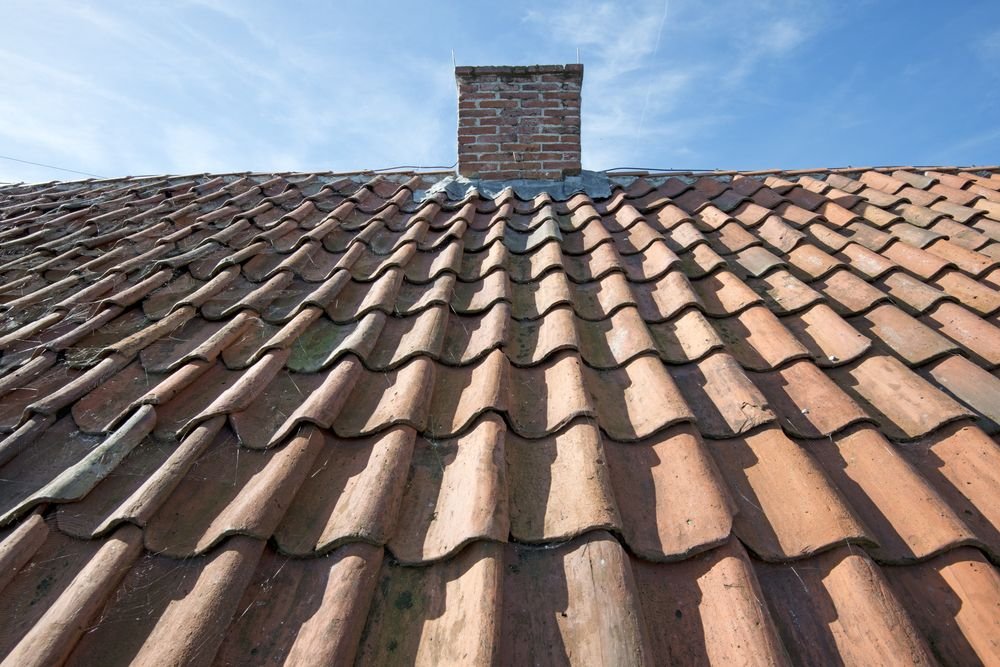 Oude dakpannen met schoorsteen en lood nieuwe tuin aanleggen